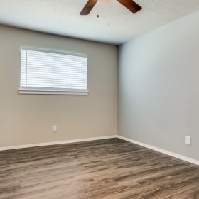 a bedroom with a ceiling fan and a window